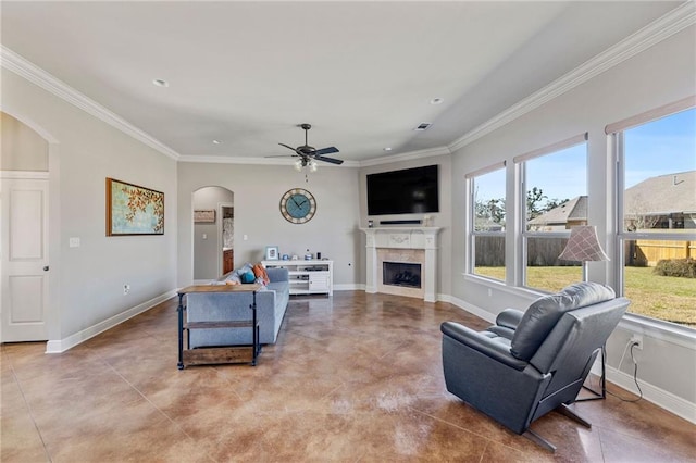 living area with plenty of natural light, a fireplace, baseboards, and crown molding