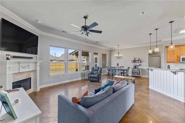 living area featuring light tile patterned floors, a tile fireplace, visible vents, baseboards, and crown molding