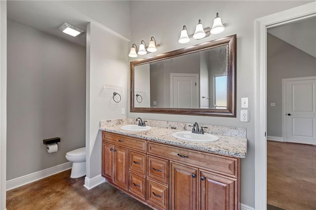 bathroom featuring toilet, baseboards, and a sink