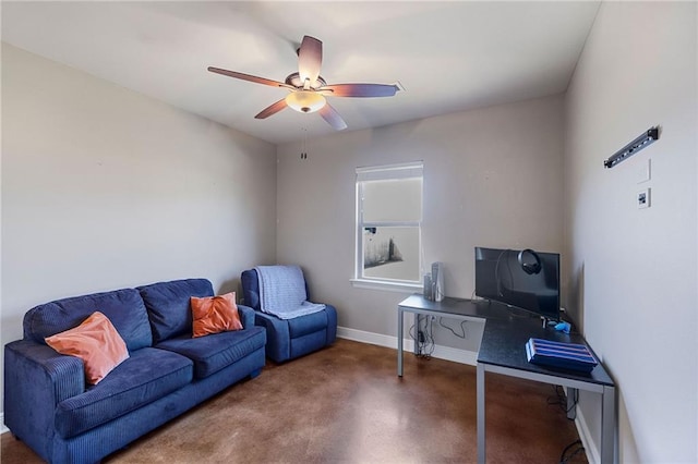 sitting room featuring finished concrete floors, ceiling fan, and baseboards