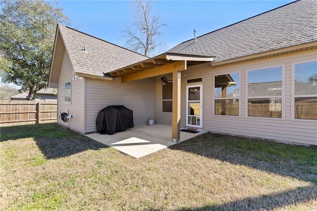 back of house featuring a shingled roof, a lawn, a ceiling fan, a patio area, and fence