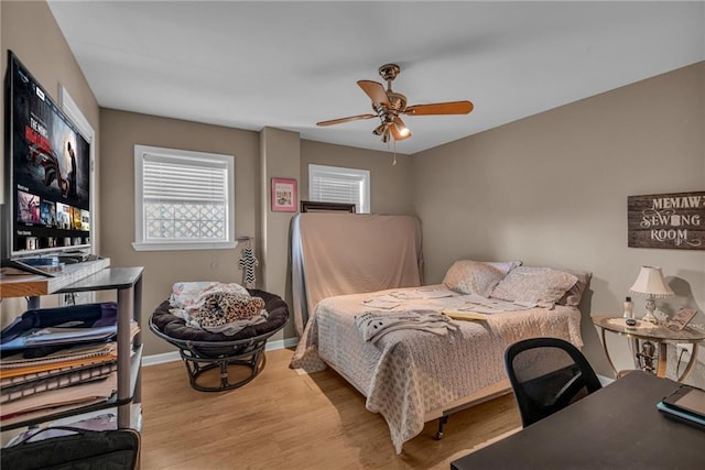 bedroom featuring ceiling fan, baseboards, and wood finished floors