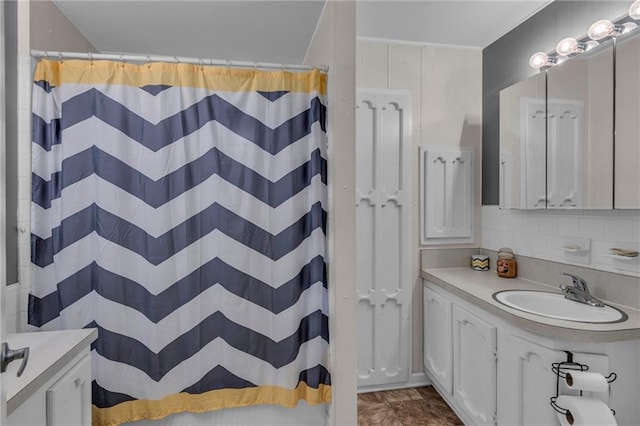 full bathroom with a shower with shower curtain, backsplash, and vanity