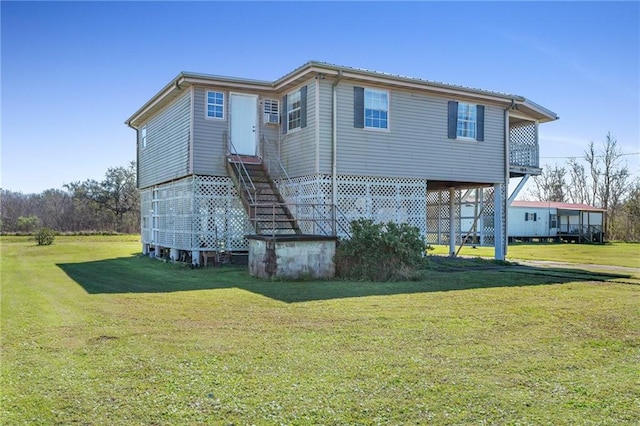 rear view of property featuring stairs and a yard