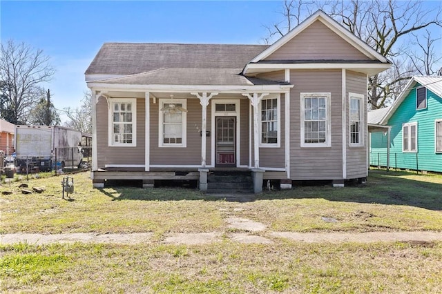 view of front of house with a porch, a front yard, and roof with shingles