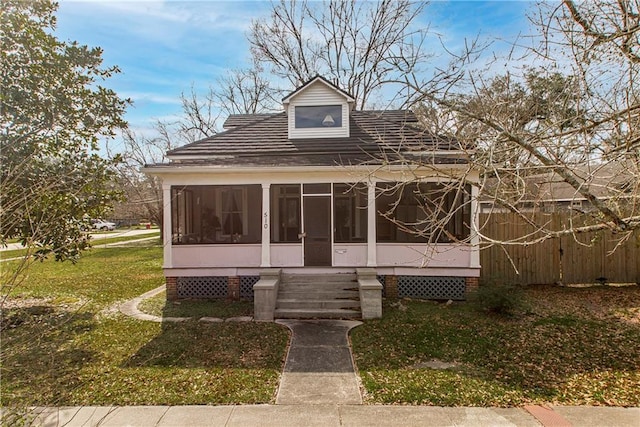 view of front of home featuring a front yard and a sunroom