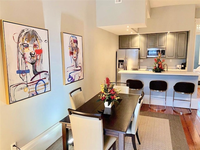 dining space featuring visible vents, baseboards, and wood finished floors