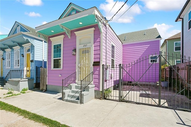 shotgun-style home featuring entry steps, driveway, crawl space, a gate, and fence