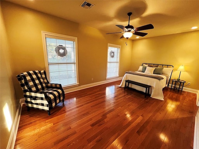 bedroom with multiple windows, wood-type flooring, visible vents, and baseboards