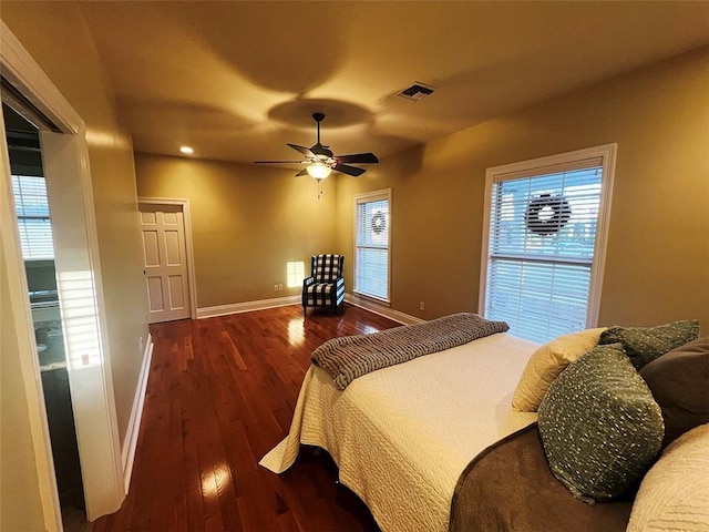 bedroom with a ceiling fan, baseboards, visible vents, and wood finished floors