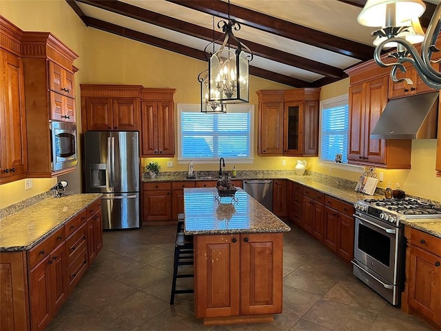 kitchen featuring vaulted ceiling with beams, under cabinet range hood, stainless steel appliances, a kitchen island, and brown cabinetry