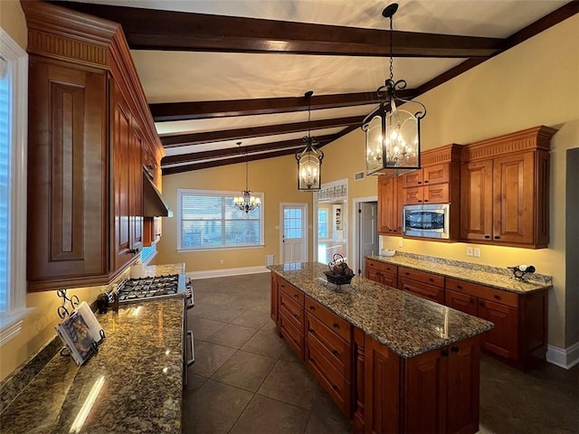 kitchen with dark stone counters, a kitchen island, vaulted ceiling with beams, an inviting chandelier, and stainless steel appliances