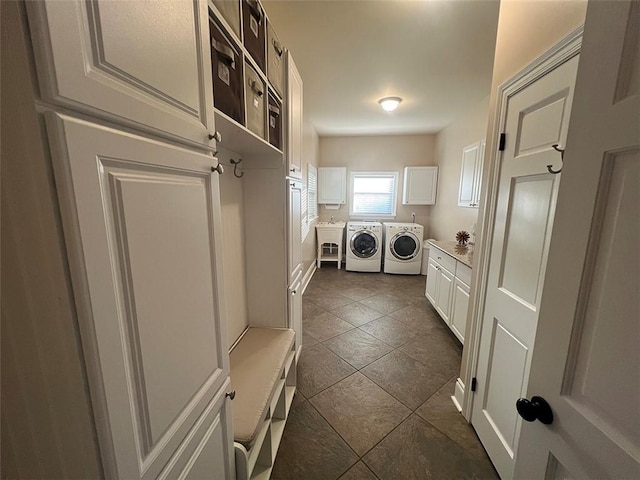 laundry area with cabinet space, dark tile patterned floors, and independent washer and dryer