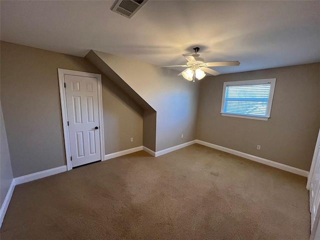 additional living space with carpet floors, baseboards, visible vents, and ceiling fan