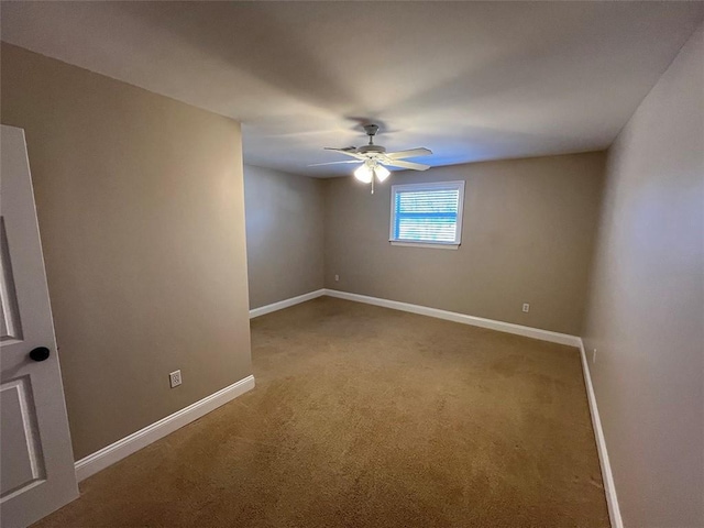 spare room featuring light carpet, ceiling fan, and baseboards