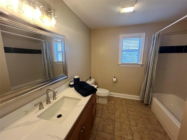 bathroom featuring baseboards, plenty of natural light, vanity, and toilet