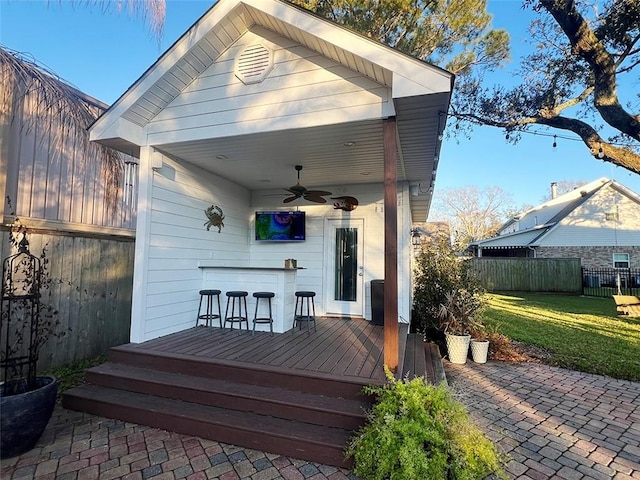 exterior space with ceiling fan, a lawn, and fence