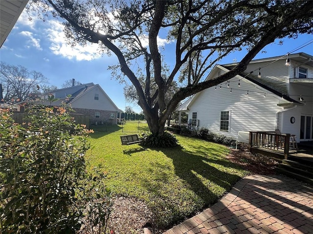 view of yard with a patio area, fence, and a wooden deck