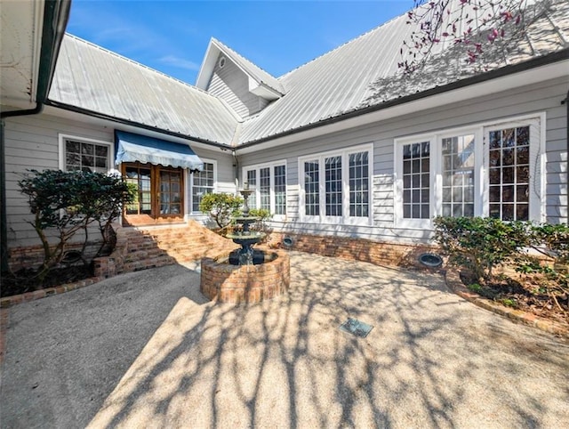 exterior space with french doors, a patio area, and metal roof