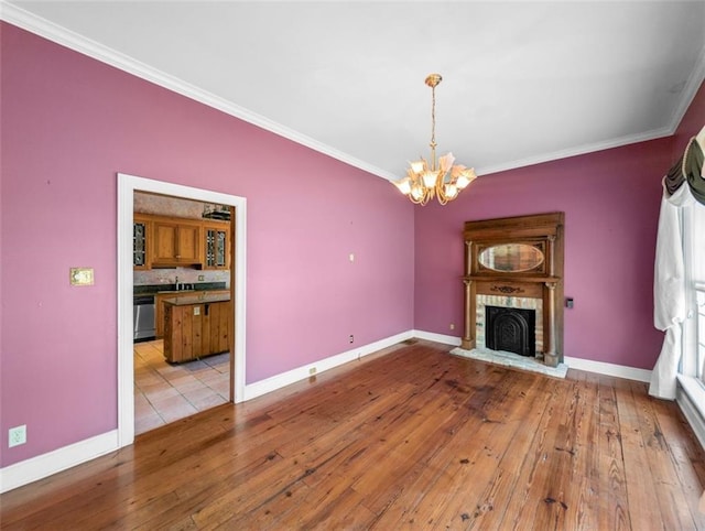 unfurnished living room featuring ornamental molding, wood-type flooring, and an inviting chandelier