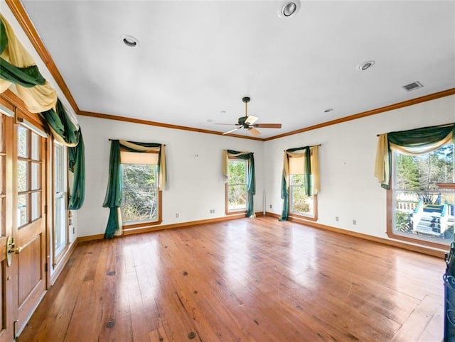 spare room with visible vents, baseboards, wood-type flooring, ceiling fan, and ornamental molding