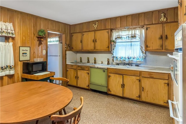 kitchen featuring a sink, freestanding refrigerator, black microwave, light countertops, and dishwasher