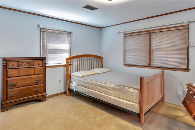 bedroom with crown molding, light colored carpet, visible vents, and baseboards