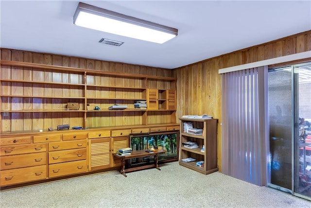 interior space with visible vents, wooden walls, and carpet floors