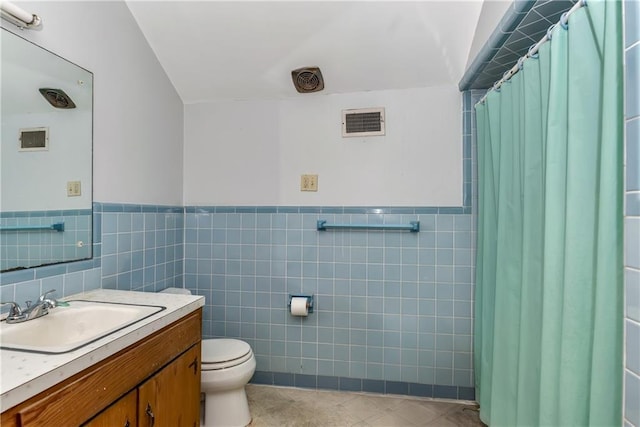 full bath featuring visible vents, toilet, vanity, a shower with curtain, and tile walls