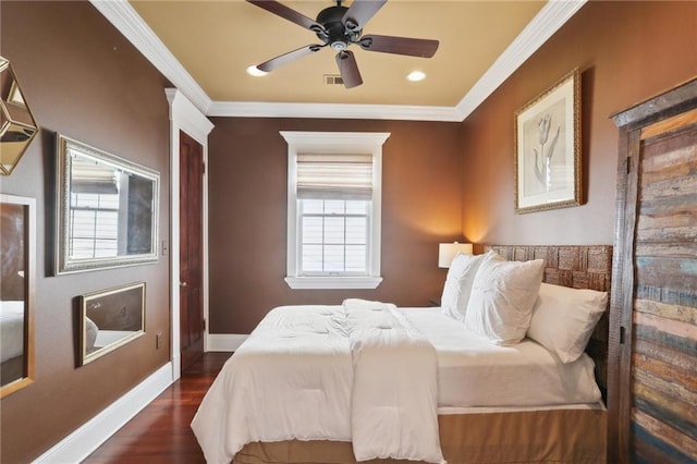 bedroom with crown molding, visible vents, ceiling fan, wood finished floors, and baseboards