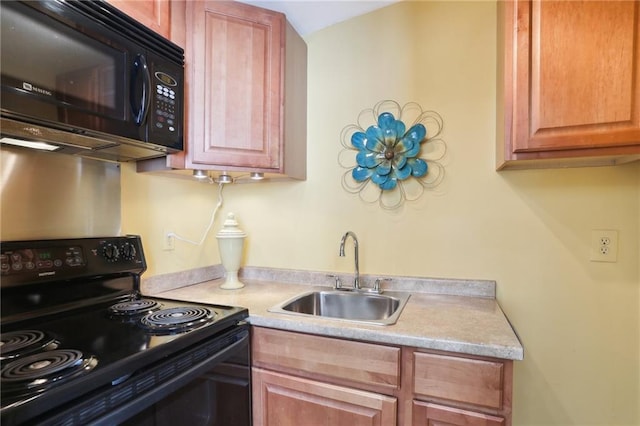 kitchen featuring black appliances, light countertops, and a sink