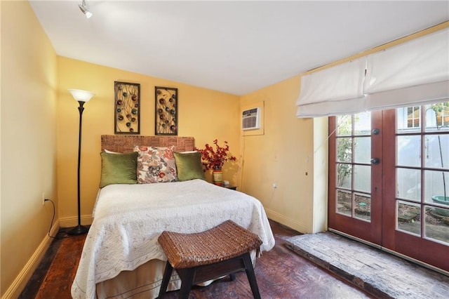 bedroom featuring baseboards, dark wood finished floors, and a wall mounted AC