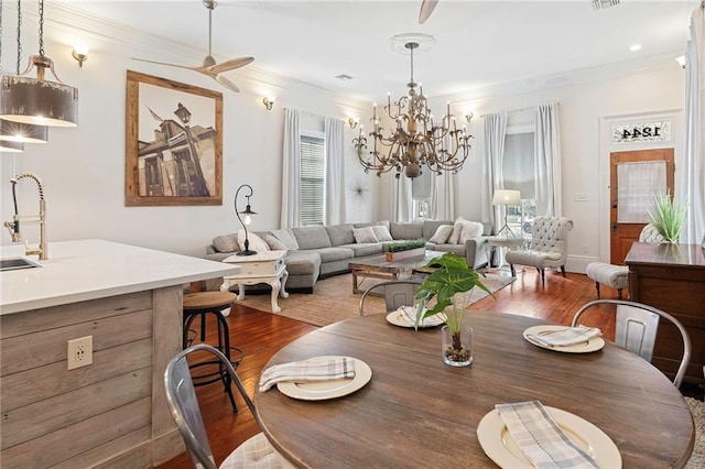 1244 Annunciation St, New Orleans, LA 70130 - dining room featuring visible vents, ornamental molding, wood finished floors, and ceiling fan with notable chandelier