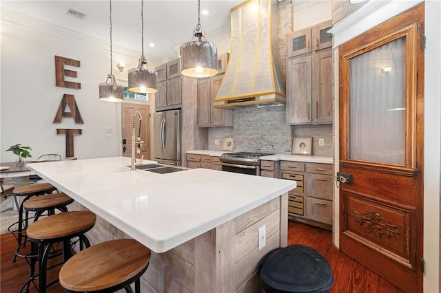 1244 Annunciation St, New Orleans, LA 70130 - kitchen featuring a center island with sink, stainless steel appliances, visible vents, premium range hood, and a kitchen bar
