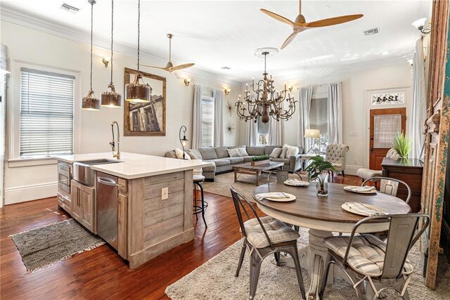 1244 Annunciation St, New Orleans, LA 70130 - dining room with ceiling fan with notable chandelier, ornamental molding, dark wood-style flooring, and visible vents