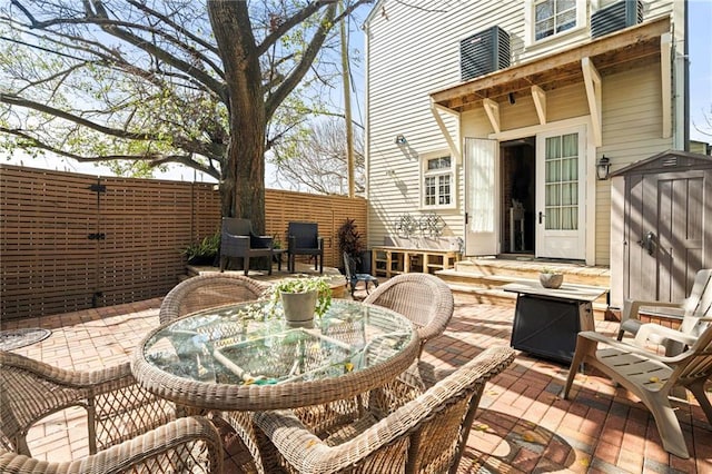 1244 Annunciation St, New Orleans, LA 70130 - view of patio / terrace with a storage shed, outdoor dining area, and an outbuilding