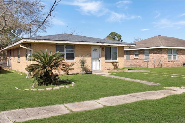 view of front of house with brick siding and a front lawn