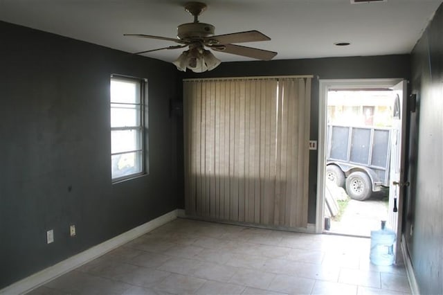 spare room featuring ceiling fan, visible vents, and baseboards