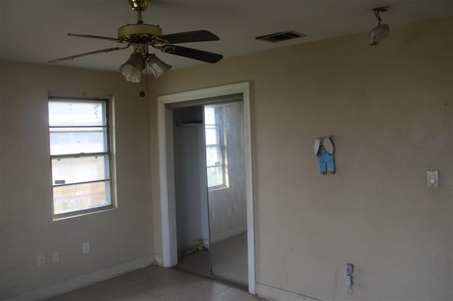 unfurnished bedroom with a ceiling fan, a closet, visible vents, and baseboards