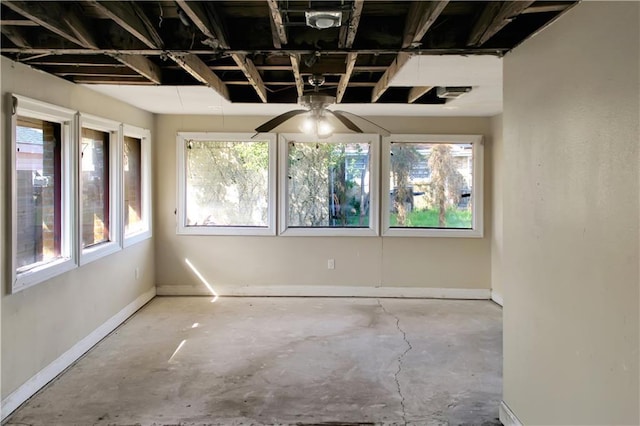 empty room with concrete flooring and baseboards