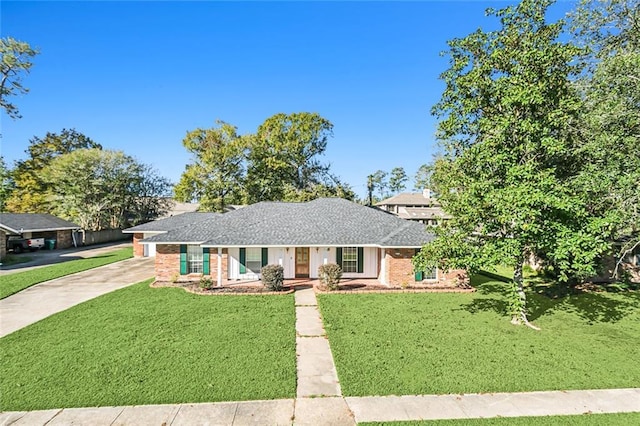 ranch-style home featuring driveway, brick siding, and a front yard