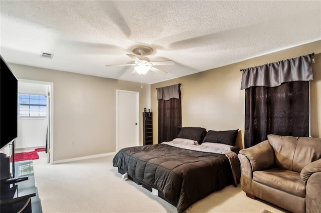 bedroom with a textured ceiling, a ceiling fan, visible vents, baseboards, and carpet