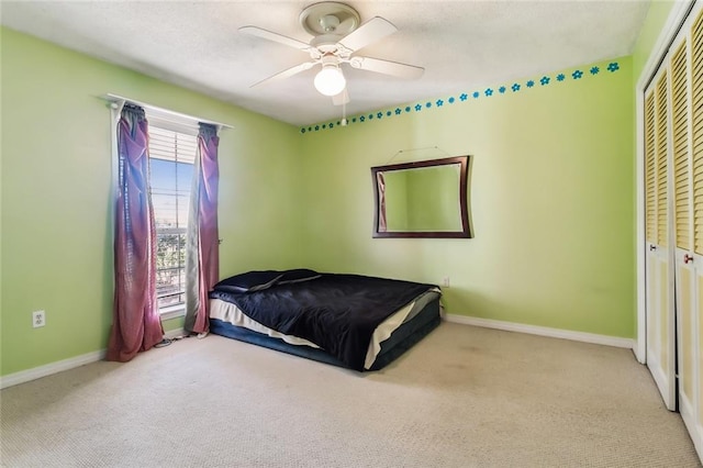 bedroom featuring carpet floors, a closet, a ceiling fan, and baseboards