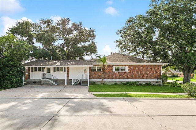 ranch-style home featuring a front yard and brick siding