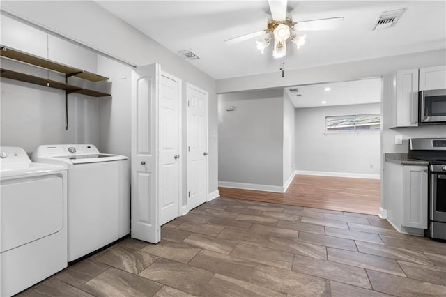 clothes washing area with washer and clothes dryer, visible vents, ceiling fan, laundry area, and baseboards