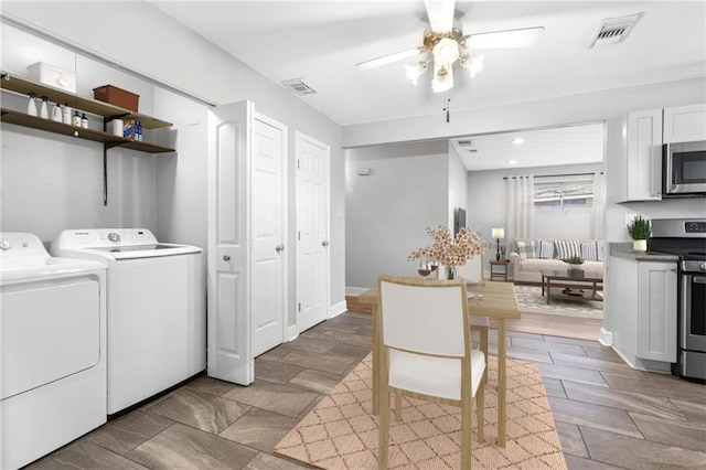 washroom with laundry area, washing machine and dryer, visible vents, and a ceiling fan