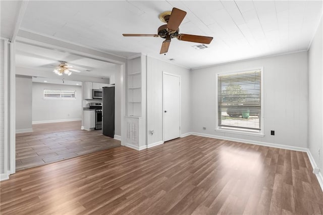 unfurnished living room featuring ceiling fan, wood finished floors, visible vents, and baseboards