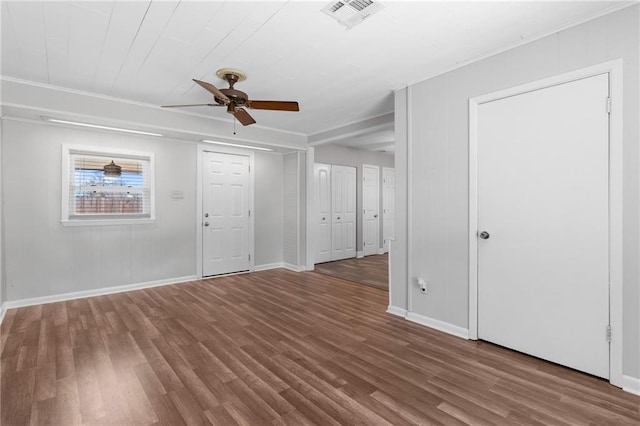 interior space featuring a ceiling fan, baseboards, visible vents, and wood finished floors