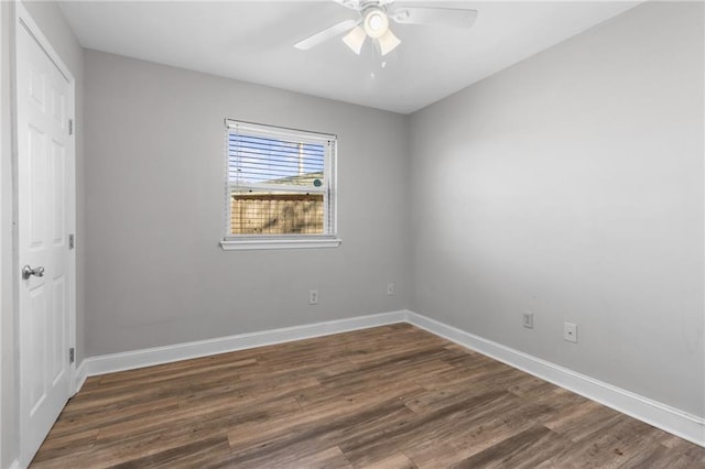 spare room with ceiling fan, baseboards, and dark wood-type flooring