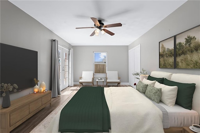 bedroom with a ceiling fan, baseboards, wood finished floors, and french doors